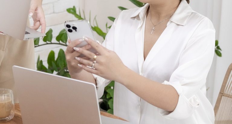 woman looks at phone as she reads the 15 SEO Basics - Free Cheatsheet For Bloggers