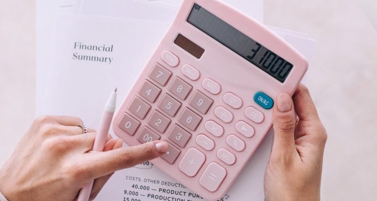 Hand typing numbers into a calculator Benefits of Budgeting That You Haven't Thought Of
