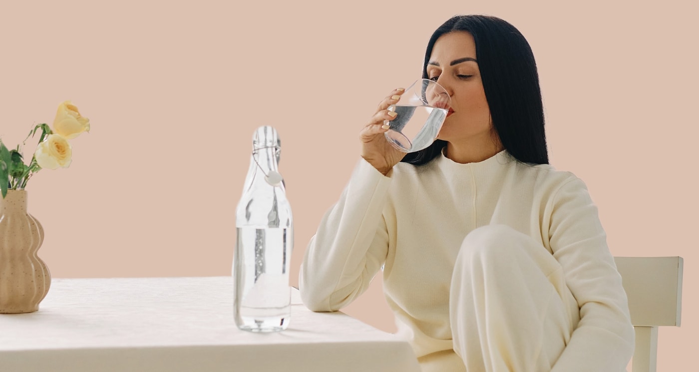 Woman in her 30s takes a sip of water and learns How to Build Wealth in Your 30's