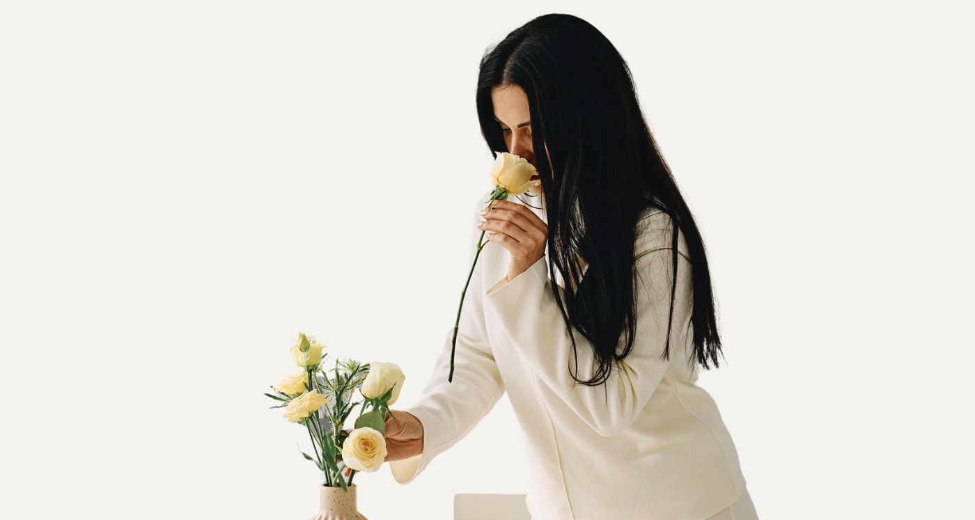 woman smells flower as she thinks about Passive Income Vs. Active Income