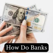 hand holding dollar bills showing how do banks make money