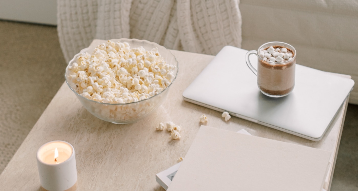 popcorn and computer on desk with guide on Ways to Deal With Financial Anxiety