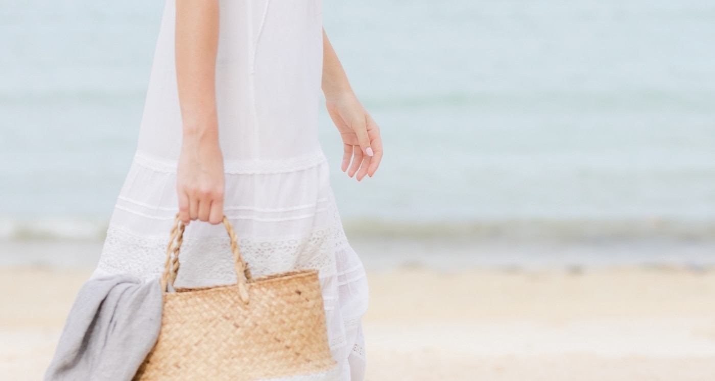 Calm woman walking on beach thinking about 16 Ways to Simplify Your Finances this year