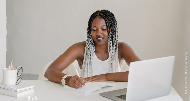 Woman writing at her desk, learning 10 Effective Time Management Tips For Building A Business Online