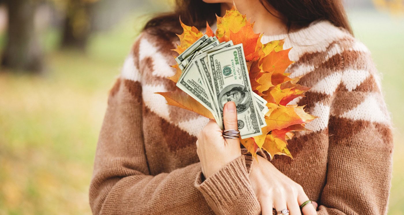 woman holds cash as she learns 31 Fall Side Hustles: How To Make Extra Money In Autumn