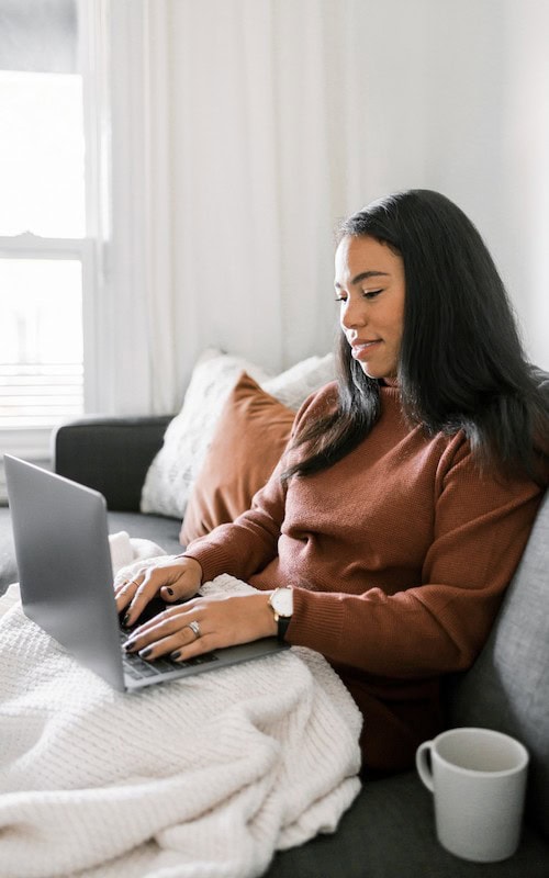 woman types on computer making money as a virtual holiday shopping assistant