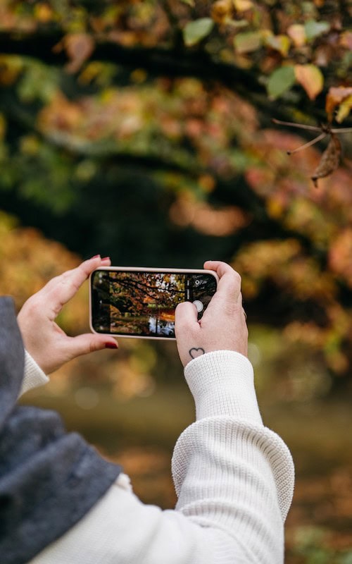 woman takes photograph as a side hustle in Fall selling Fall photos