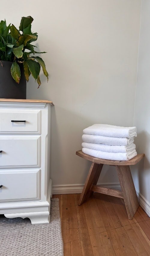 Cottage Weekend Ideas: Escape to The Tides on Pender Island 8 a stack of towels on a stool next to a plant