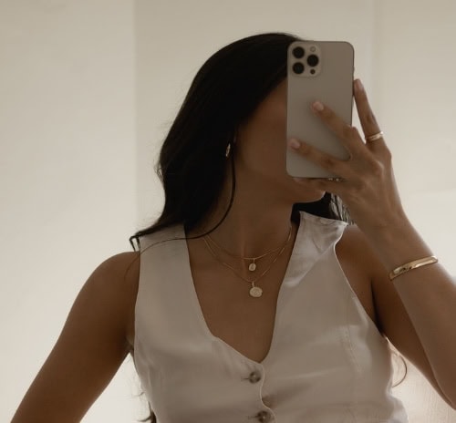 woman looks at phone to see creator economy website investing book - where to buy glow up yourself book chelsea clarke